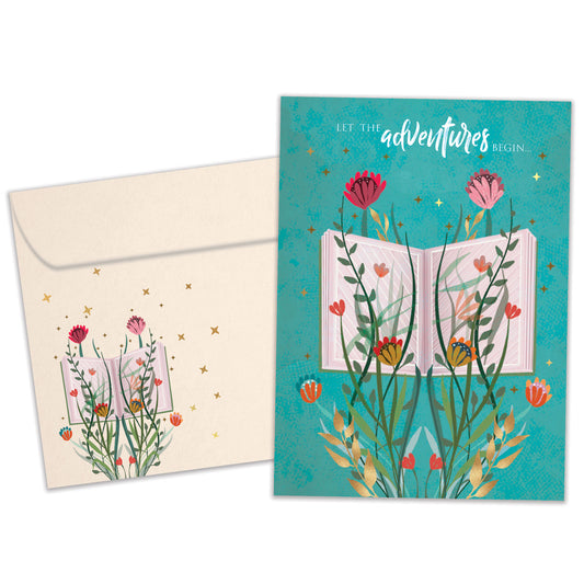 Front view of a Birthday greeting card featuring an open book with flowers and a message about adventures, with a matching envelope.