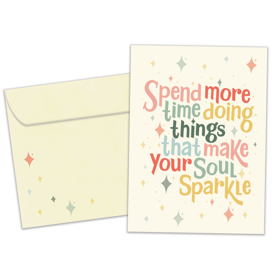 Front view of a Birthday greeting card featuring the message "spend more time doing things that make your soul sparkle" on a light yellow background, with a matching envelope.