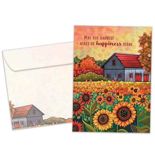 Front view of a birthday greeting card featuring an illustration of a barn and sunflowers in brilliant autumn colours with a heartfelt message, with a matching envelope.