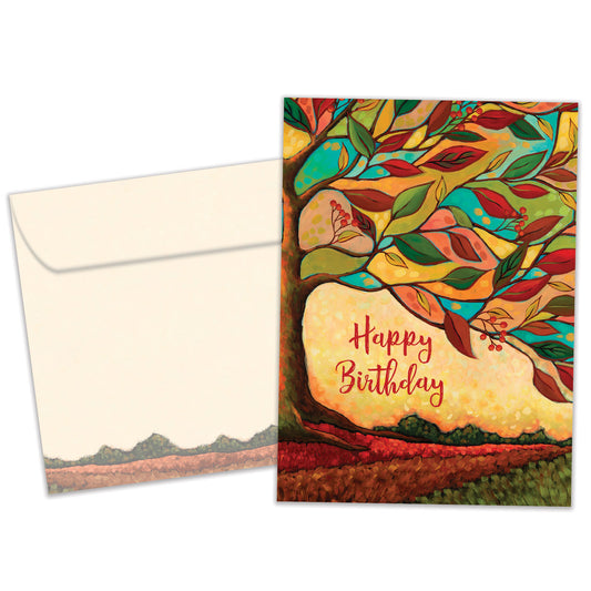 Front view of a birthday greeting card featuring the message "happy birthday" surrounded by a tree and vibrant fall colours, with a matching envelope.