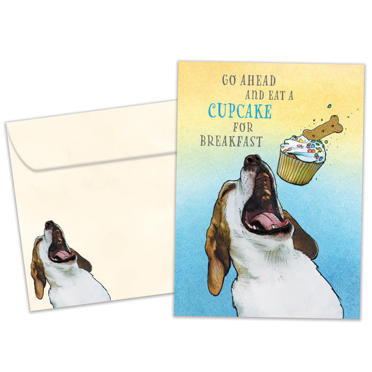 Front view of a Birthday greeting card featuring a playful image of a dog eating a cupcake and a fun message, with a matching envelope.