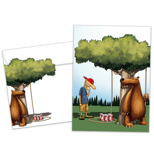 Front view of a Birthday greeting card and matching envelope featuring a fun illustration of a bear setting up a trap for a man.