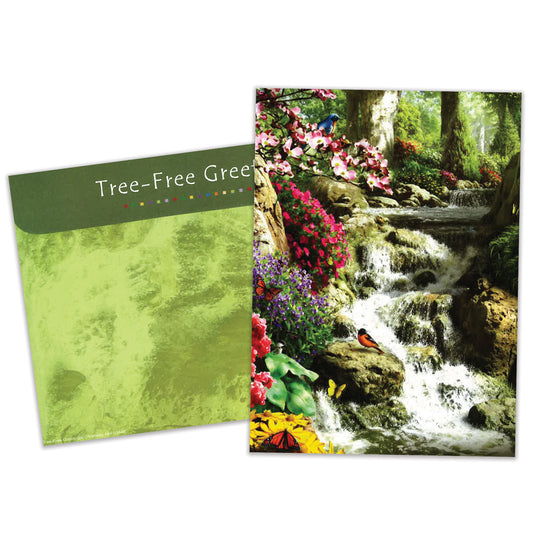 Front view of a Birthday greeting card featuring a serene forest and waterfall scene with flowers and birds, with a matching envelope.