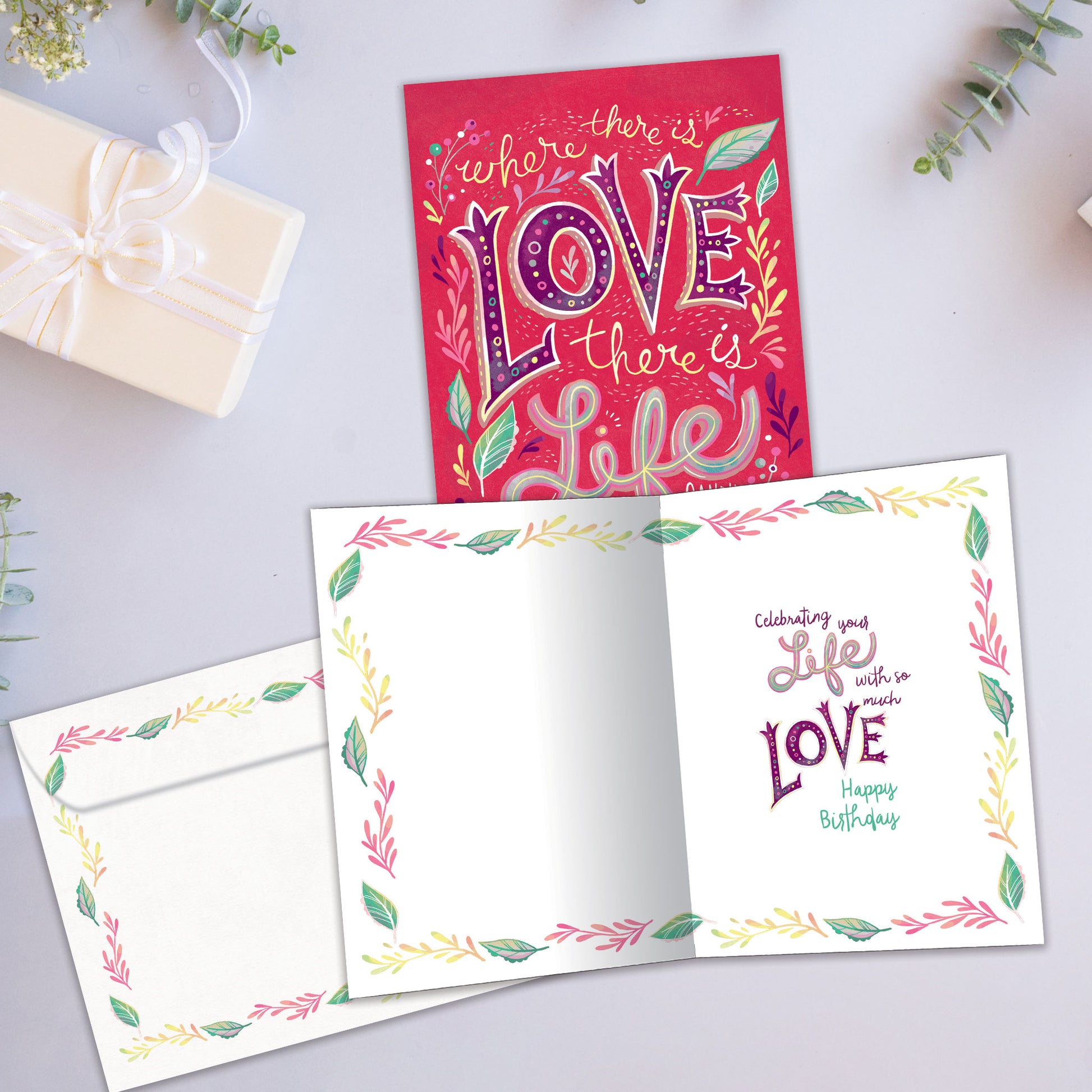 Front and inside view of a Birthday greeting card showcasing a pink background with the words "where there is love there is life", with a matching envelope.