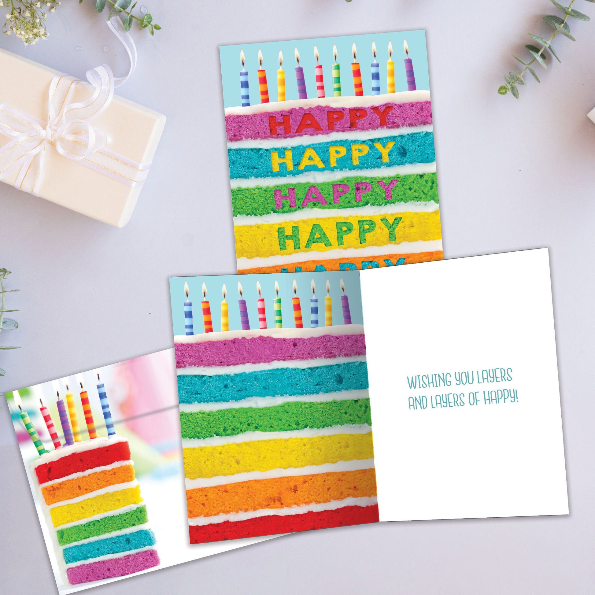 Front and inside view of a Birthday greeting card showcasing a slice of cake with colourful layers and birthday candles, with a matching envelope.