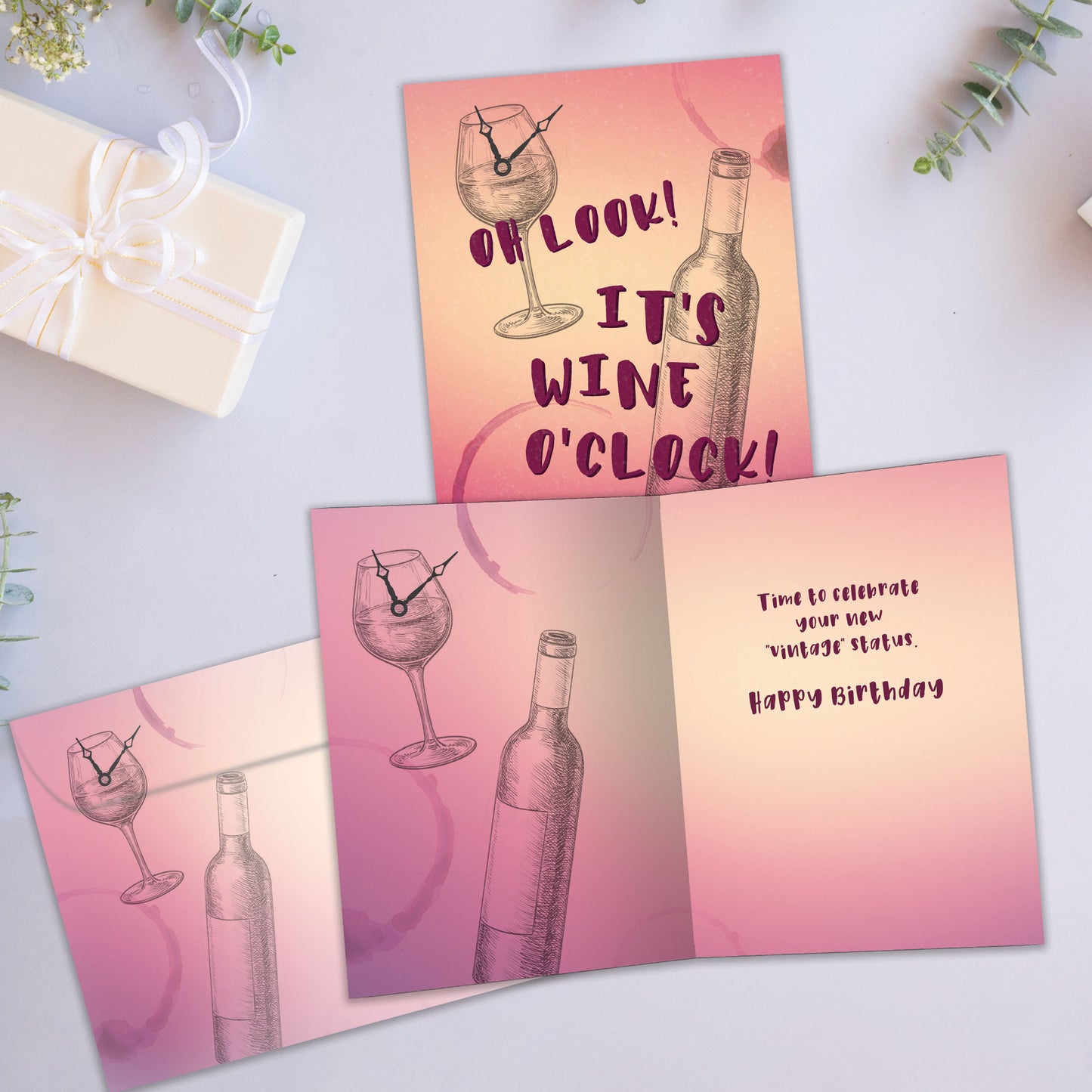 Front and inside view of a Birthday greeting card showcasing a sketch of a wine glass with a clock and the words "It's wine o'clock", with a matching envelope.
