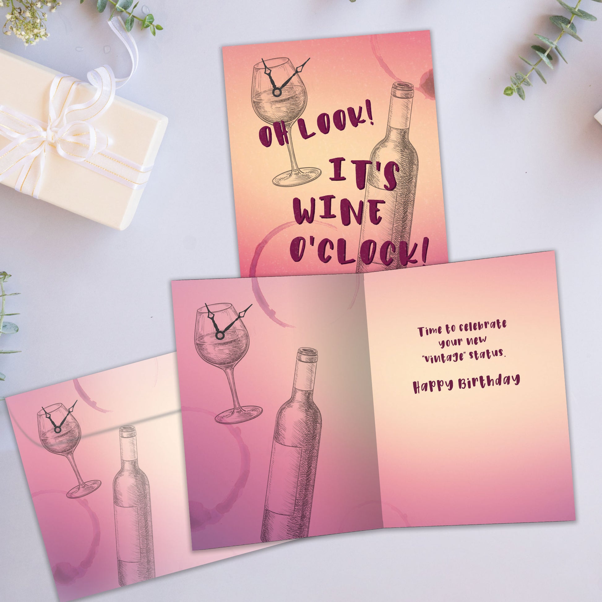 Front and inside view of a Birthday greeting card showcasing a sketch of a wine glass with a clock and the words "It's wine o'clock", with a matching envelope.