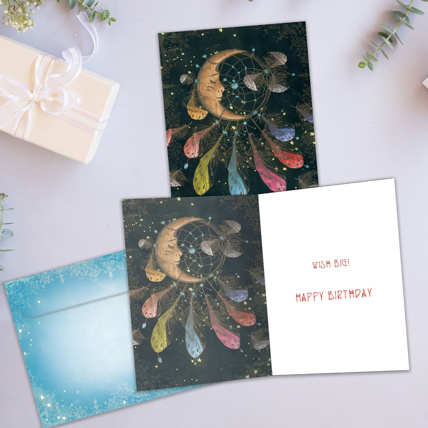 Front and inside view of a Birthday greeting card showcasing an illustration of a sleeping moon dreamcatcher, with a matching envelope.