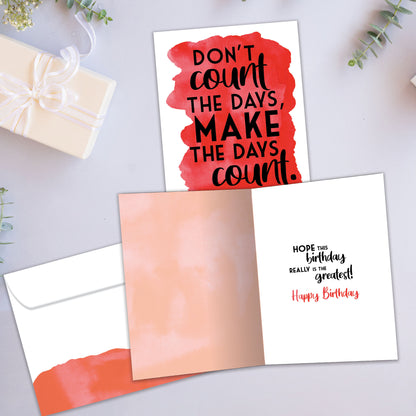 Front and inside view of a Birthday greeting card showcasing the words "don't count the days, make the days count" on a red background, with a matching envelope.