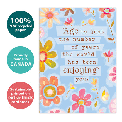 Front view of a Birthday greeting card with pastel-colored flowers and a message about age being just a number, highlighting its eco-friendly materials and made in Canada.