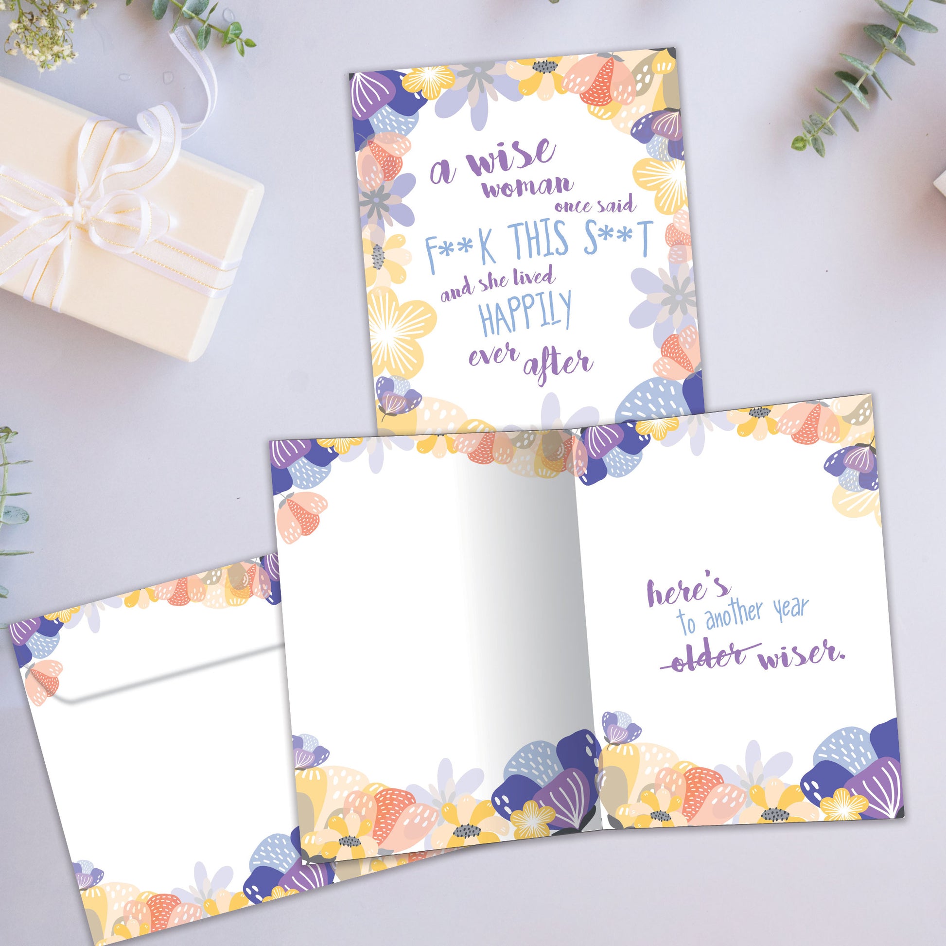 Front and inside view of a Birthday greeting card showcasing a floral design surrounding sarcastic words about a wise woman, with a matching envelope.