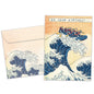 Front view of a Birthday greeting card featuring an illustration of friends in a raft paddling on a giant wave, with a matching envelope.