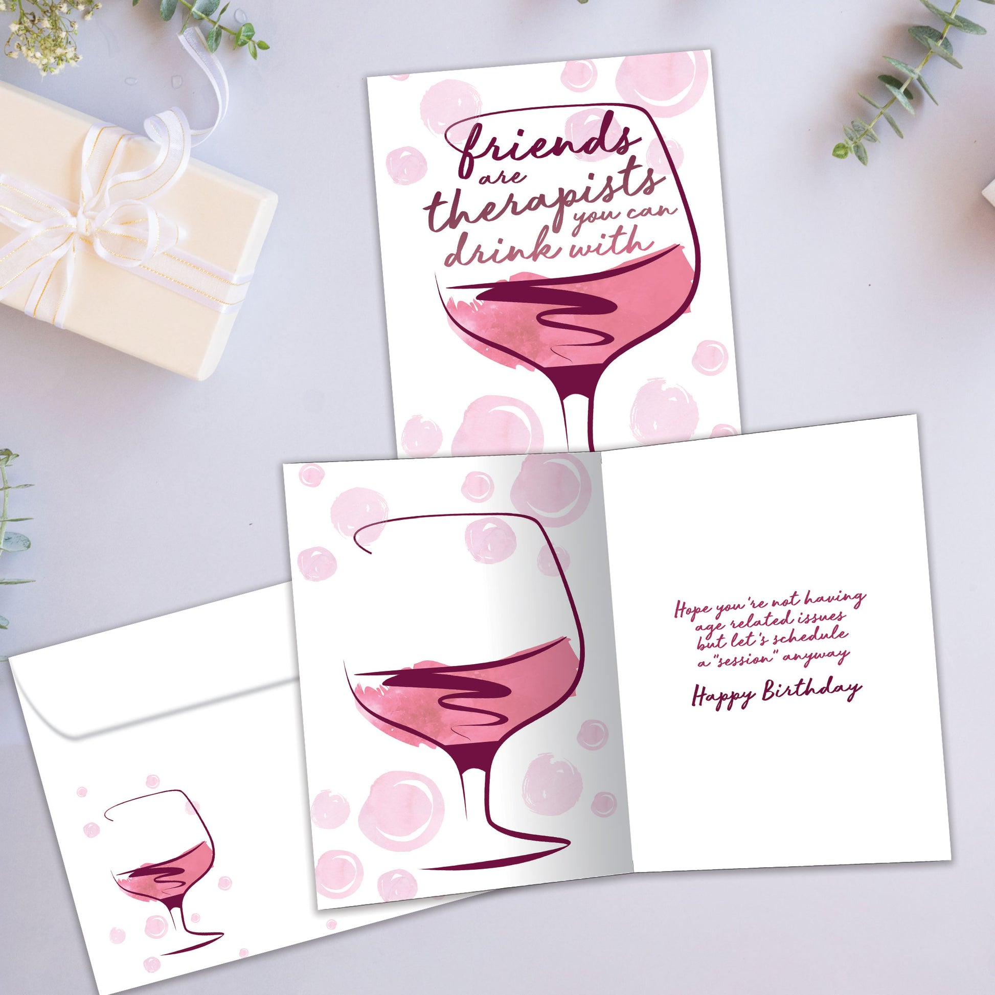 Front and inside view of a Birthday greeting card showcasing an illustration of a glass of wine with a message about friends being therapists, with a matching envelope.