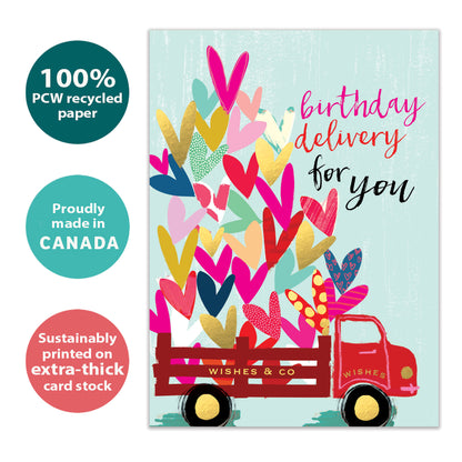Front view of a Birthday greeting card with an illustration of a delivery truck filled with hearts, highlighting its eco-friendly materials and made in Canada.
