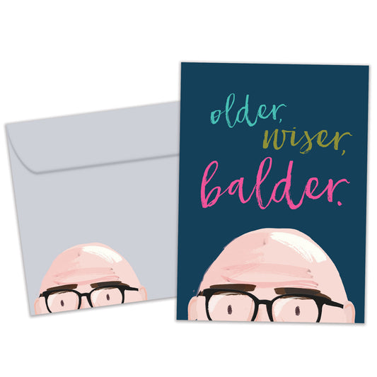 Front view of a Birthday greeting card featuring the top of a bald man's head with the words "older, wiser, balder", with a matching envelope.