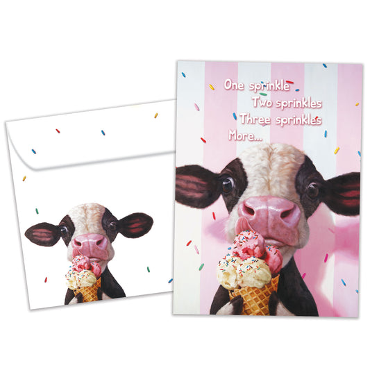 Front view of a Birthday greeting card featuring a cow licking an ice cream cone on a pinkish background, with a matching envelope.