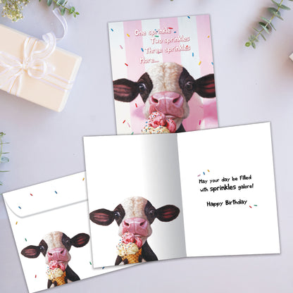 Front and inside view of a Birthday greeting card showcasing a cow licking an ice cream cone on a pinkish background, with a matching envelope.