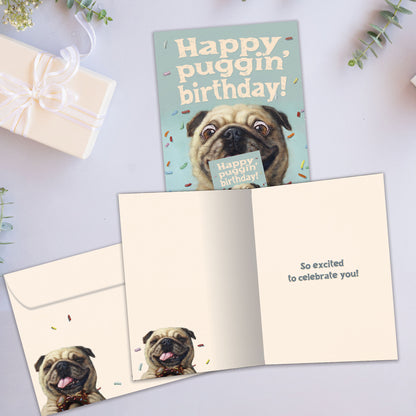 Front and inside view of a Birthday greeting card showcasing a playful dog design with the message "happy puggin' birthday", with a matching envelope.