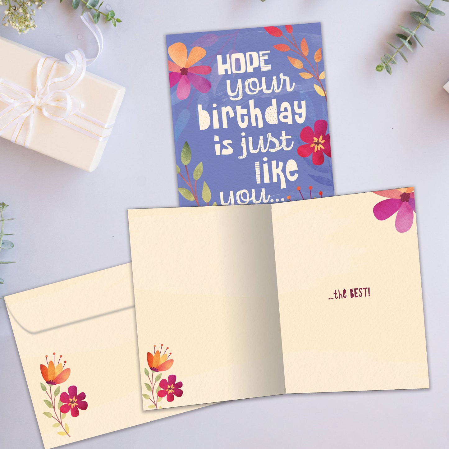 Front and inside view of a Birthday greeting card showcasing a floral design on a purple background with a birthday message, with a matching envelope.