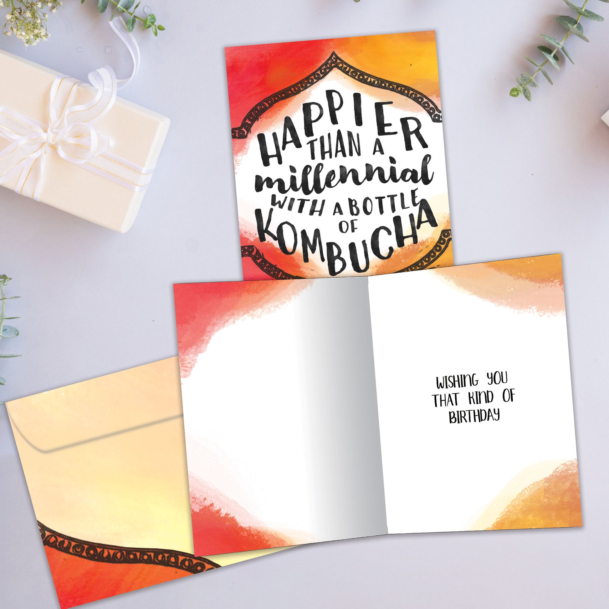Front and inside view of a Birthday greeting card showcasing a colourful background with a message about being happier than a millennial, with a matching envelope.