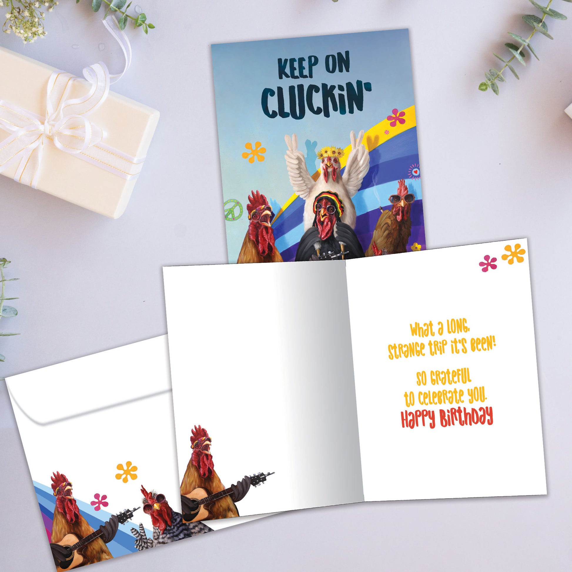 Front and inside view of a Birthday greeting card showcasing partying roosters with the words "keep on cluckin'", with a matching envelope.