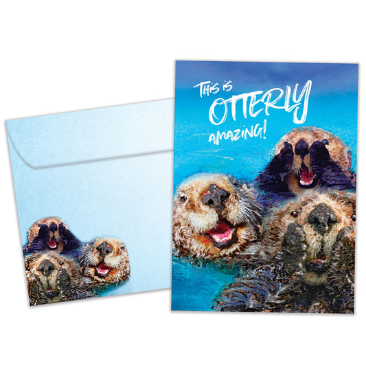 Front view of a Birthday greeting card featuring otters with the message "this is otterly amazing!", with a matching envelope.