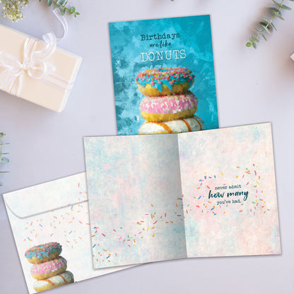 Front and inside view of a Birthday greeting card showcasing a stack of donuts with the message "birthdays are like donuts", with a matching envelope.