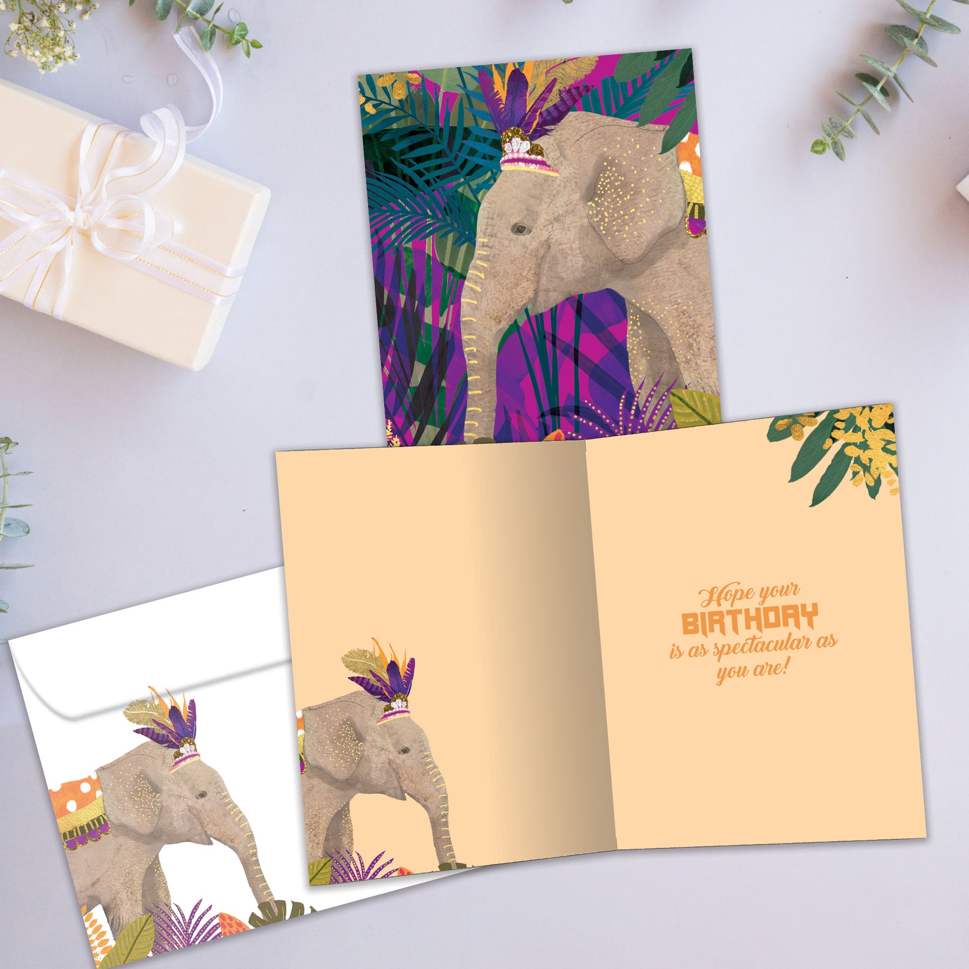 Front and inside view of a Birthday greeting card showcasing an elephant wearing a crown on a colourful foliage background, with a matching envelope.