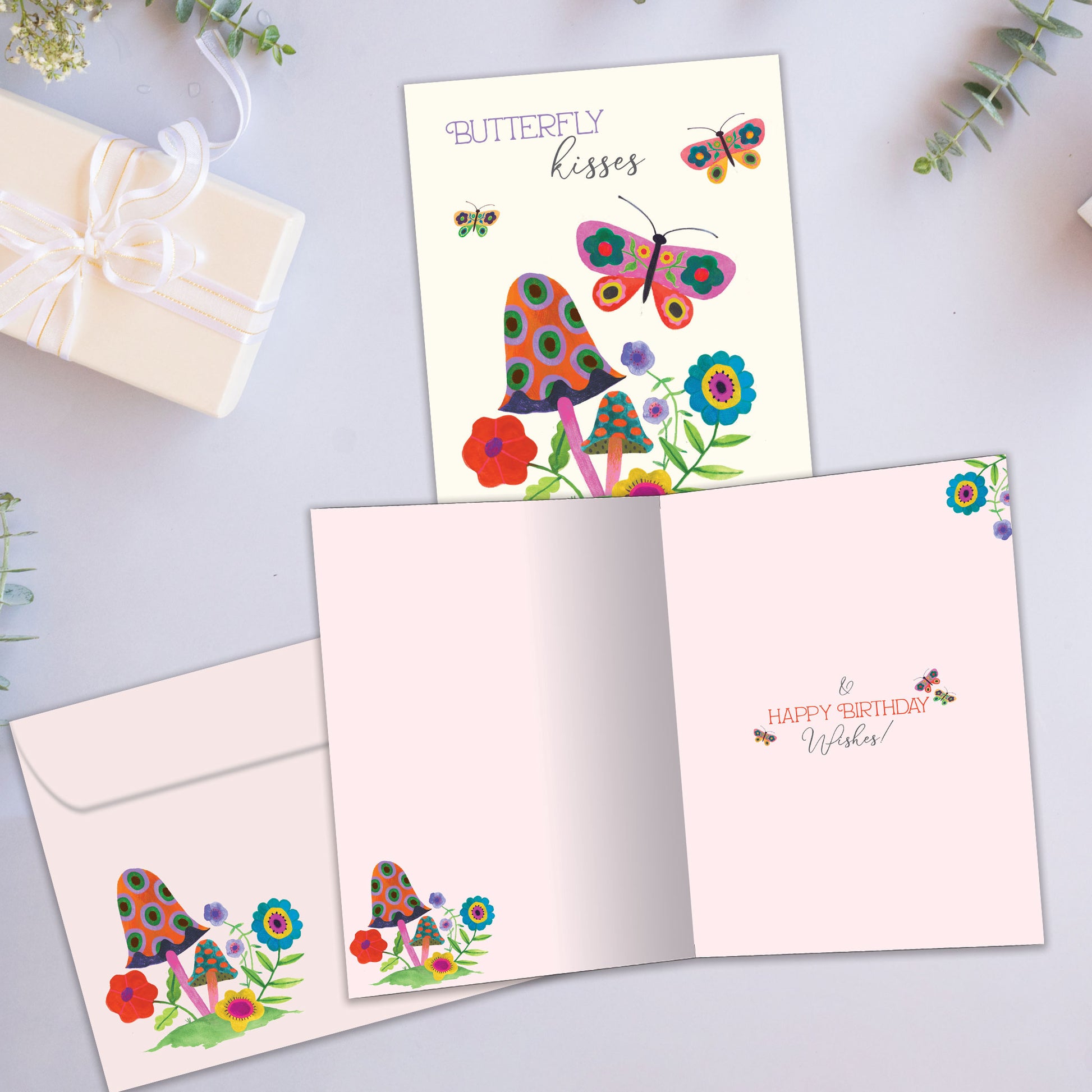 Front and inside view of a Birthday greeting card showcasing butterflies and flowers with the message "butterfly kisses", with a matching envelope.