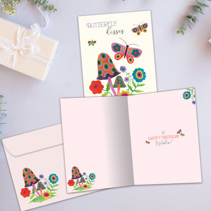 Front and inside view of a Birthday greeting card showcasing butterflies and flowers with the message "butterfly kisses", with a matching envelope.