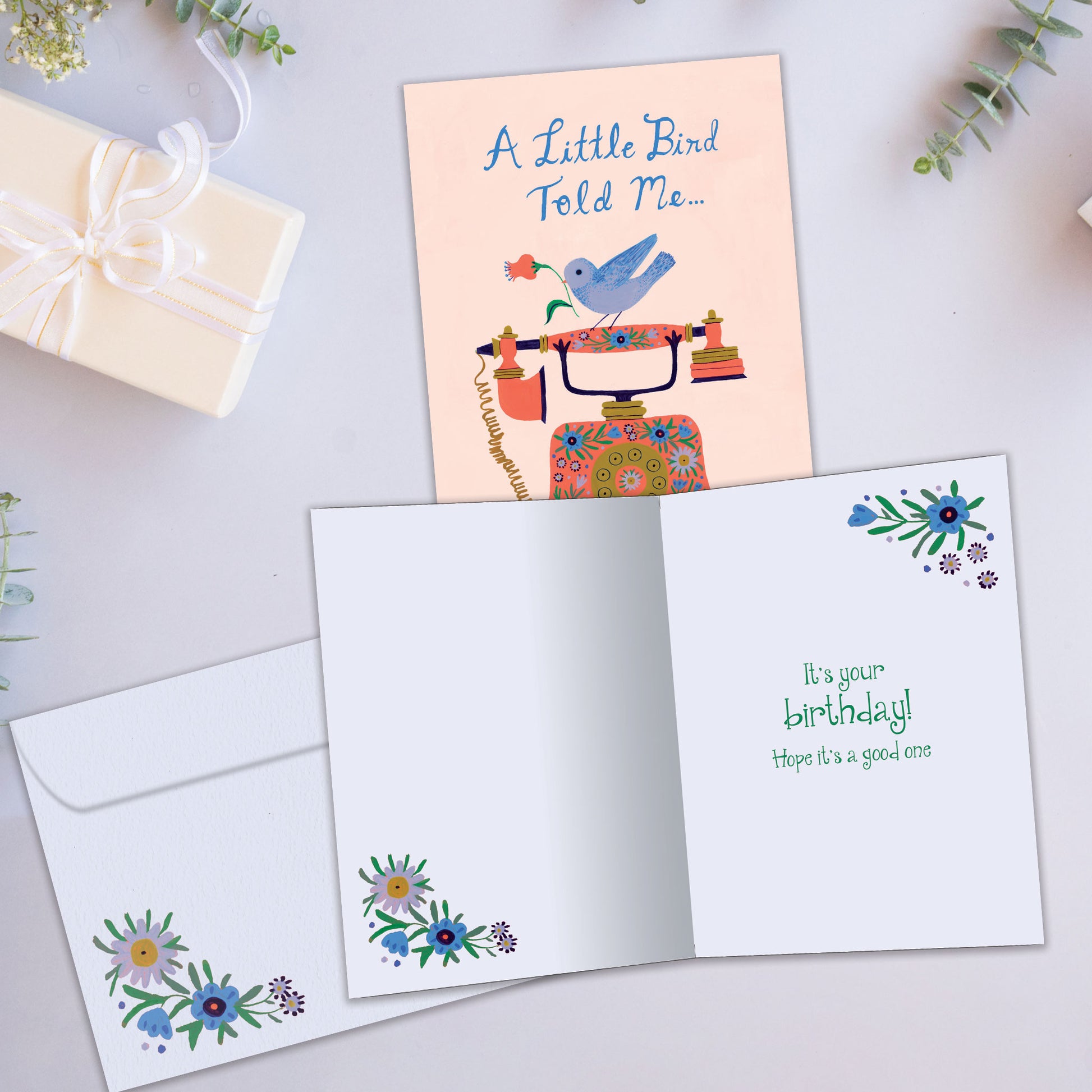 Front and inside view of a Birthday greeting card showcasing a bird on a phone with the message "a little bird told me...", with a matching envelope.