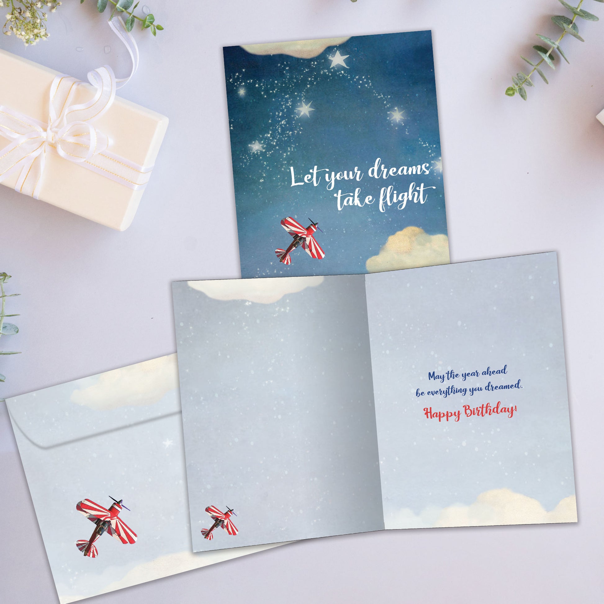 Front and inside view of a Birthday greeting card showcasing an airplane flying in the sky with the message "let your dreams take flight", with a matching envelope.