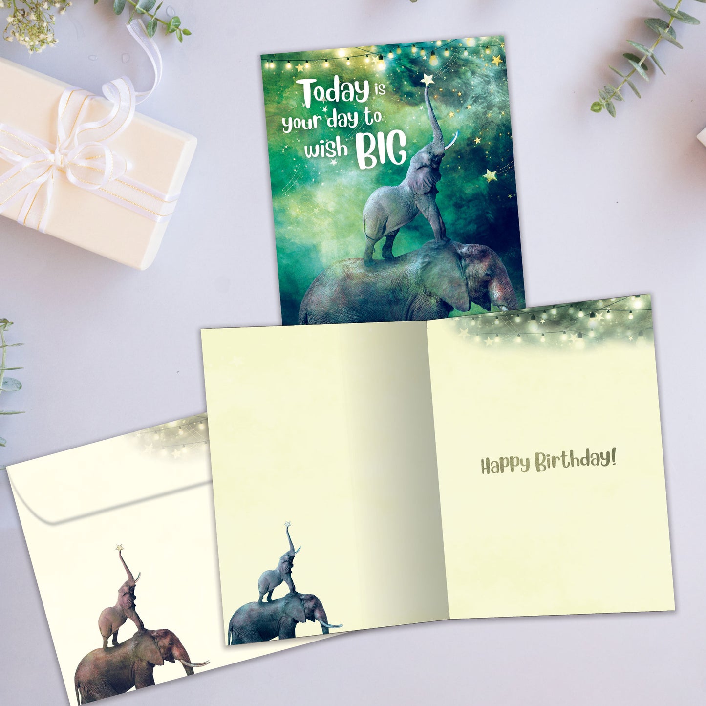 Front and inside view of a birthday greeting card showcasing an illustration of a baby and mother elephants with the message "Today is your day to wish big", with a matching envelope.