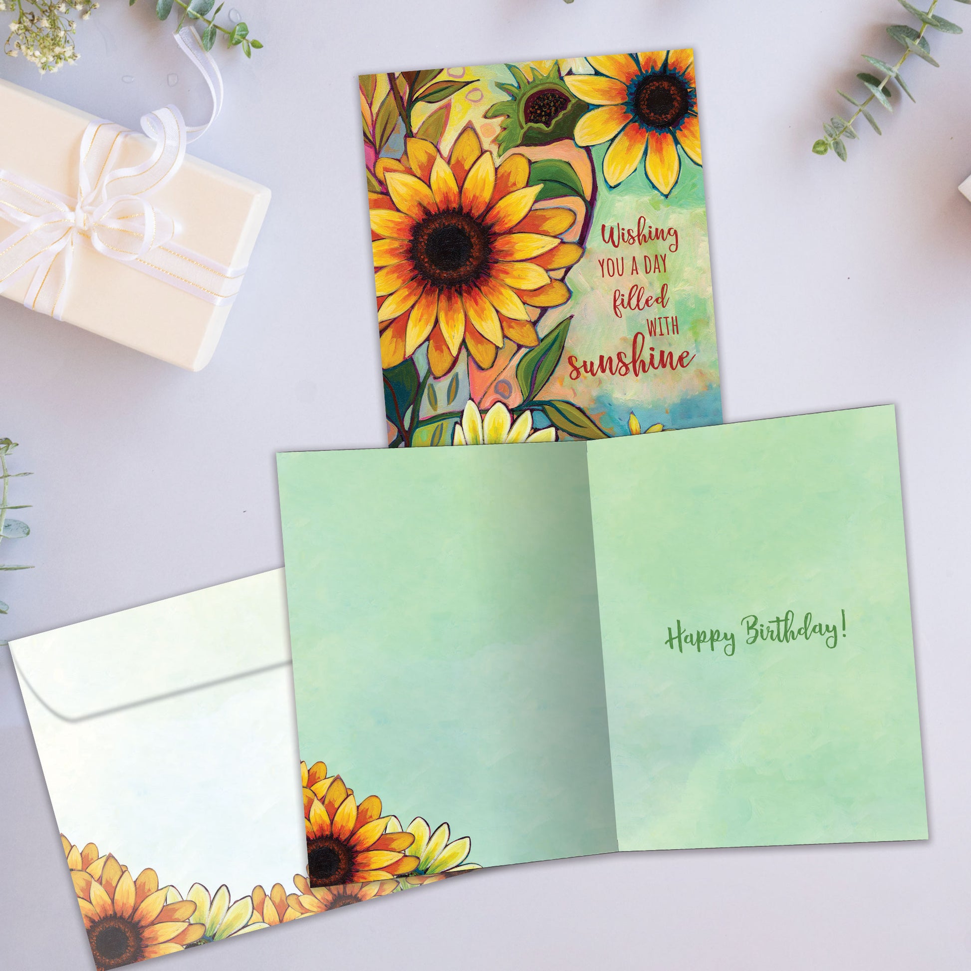 Front and inside view of a birthday greeting card showcasing the message "wishing you a day filled with sunshine" and flowers in vibrant fall colours, with a matching envelope.