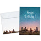 Front view of a birthday greeting card featuring an illustration of a family sitting and playing guitar around a campfire with the message "Happy Birthday!", with a matching envelope.