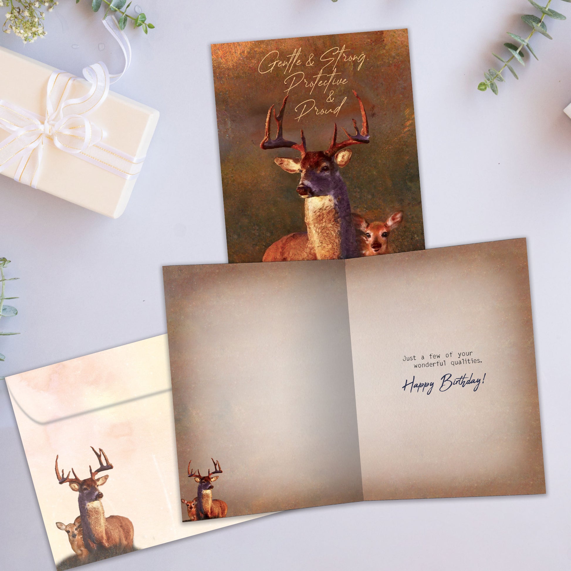 Front and inside view of a birthday greeting card showcasing an illustration of a buck and fawn with the message "Gentle & strong, protective & proud", with a matching envelope.