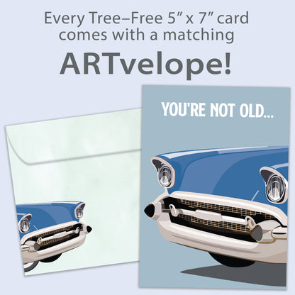 Front view of a birthday greeting card featuring an illustration of a classic car with the message "you're not old...", with matching envelope artwork.