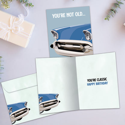 Front and inside view of a birthday greeting card showcasing an illustration of a classic car with the message "you're not old...", with a matching envelope.