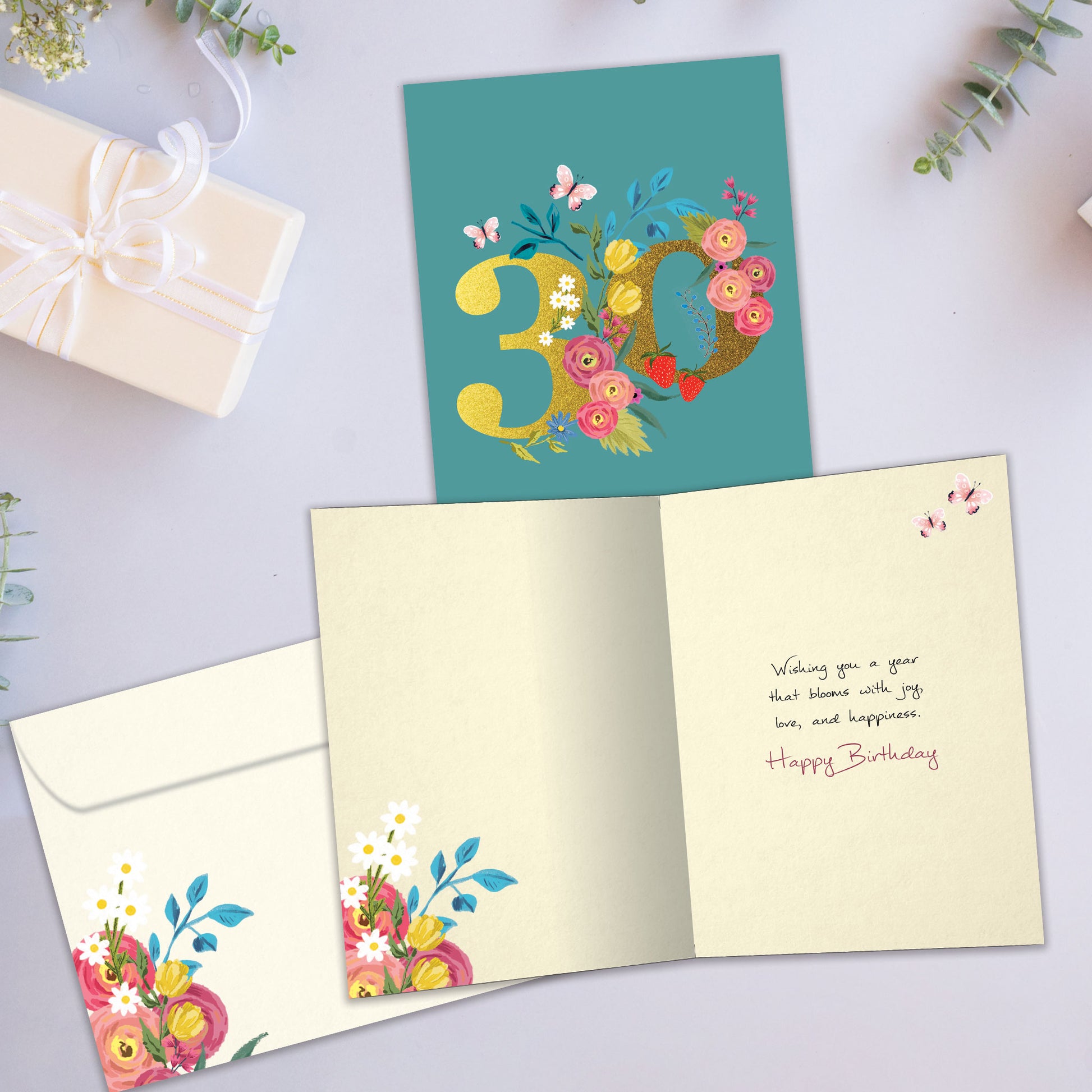 Front and inside view of a Birthday greeting card showcasing a large number 30 with floral accents on a teal background, with a matching envelope.
