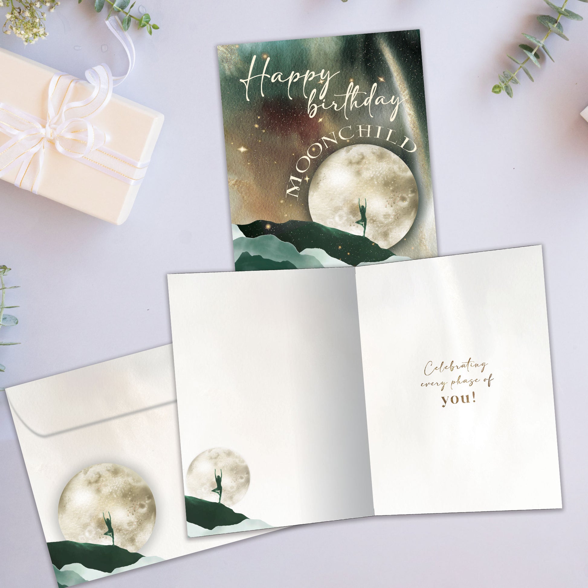 Front and inside view of a Birthday greeting card showcasing a moon and mountains scene with a birthday message, with a matching envelope.