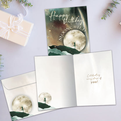 Front and inside view of a Birthday greeting card showcasing a moon and mountains scene with a birthday message, with a matching envelope.