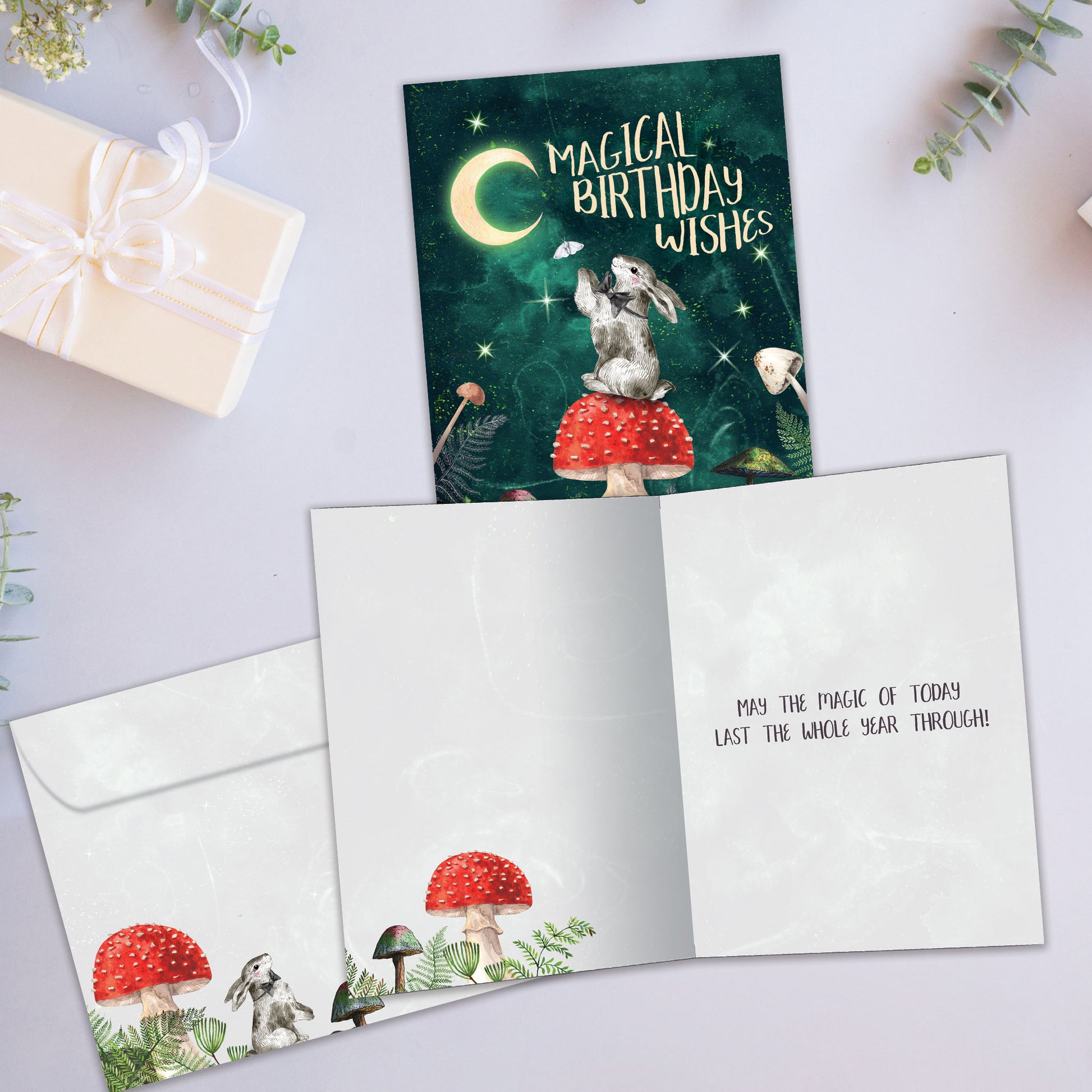 Front and inside view of a Birthday greeting card showcasing a bunny on a mushroom under the moon and a birthday messsage, with a matching envelope