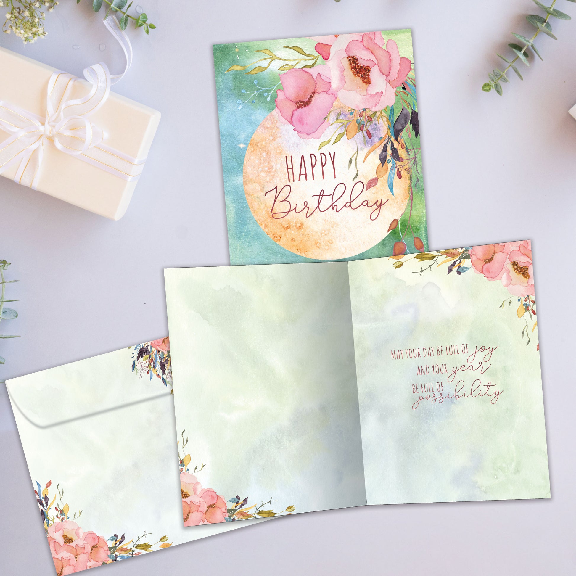 Front and inside view of a Birthday greeting card showcasing a floral design with the message "Happy Birthday", with a matching envelope.