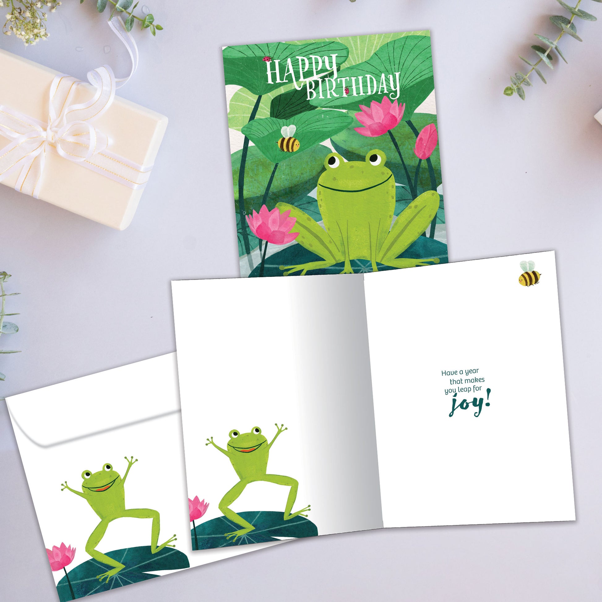 Front and inside view of a Birthday greeting card showcasing a happy frog with the message "Happy Birthday", with a matching envelope.