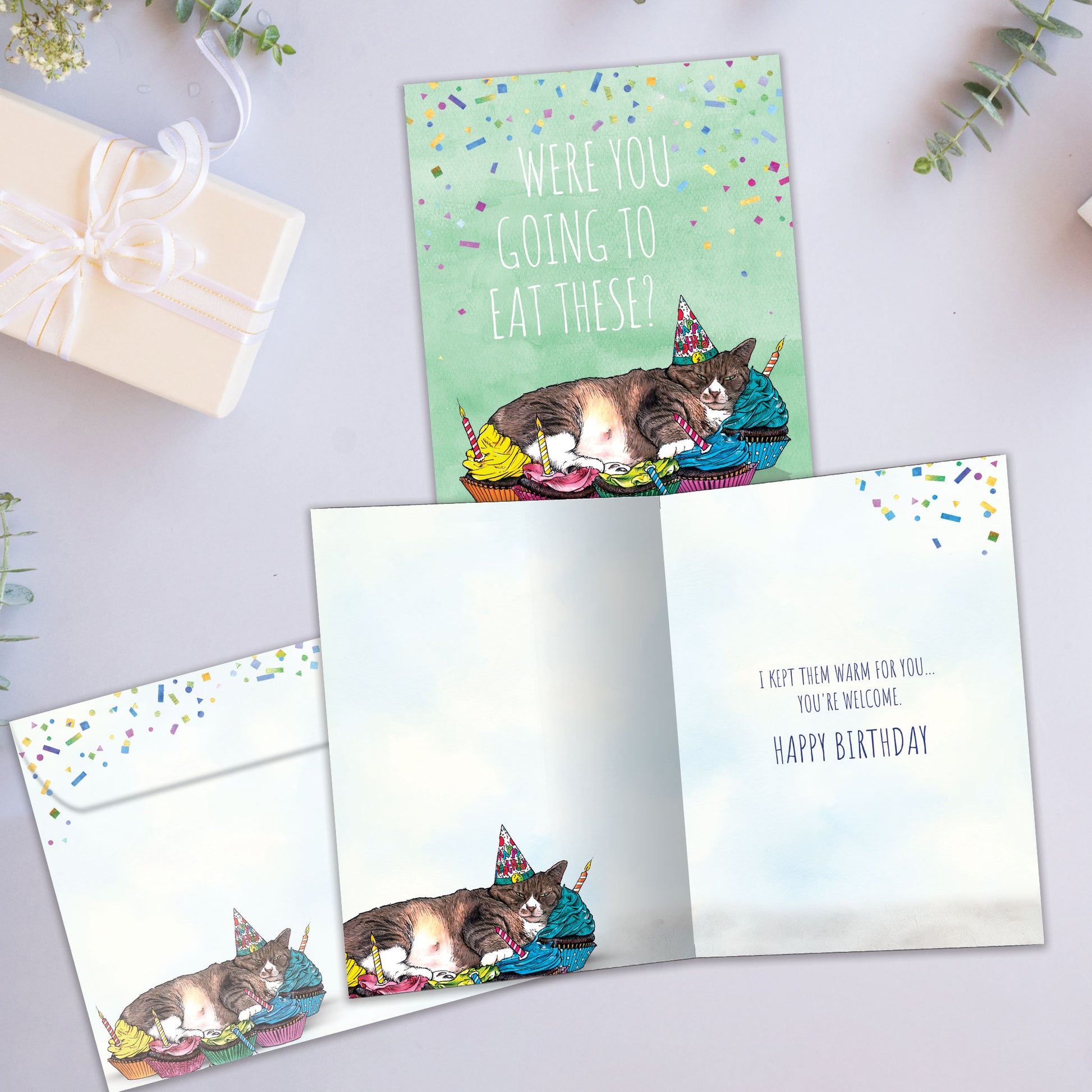 Front and inside view of a Birthday greeting card showcasing a napping cat surrounded by cupcakes and a message, with a matching envelope.