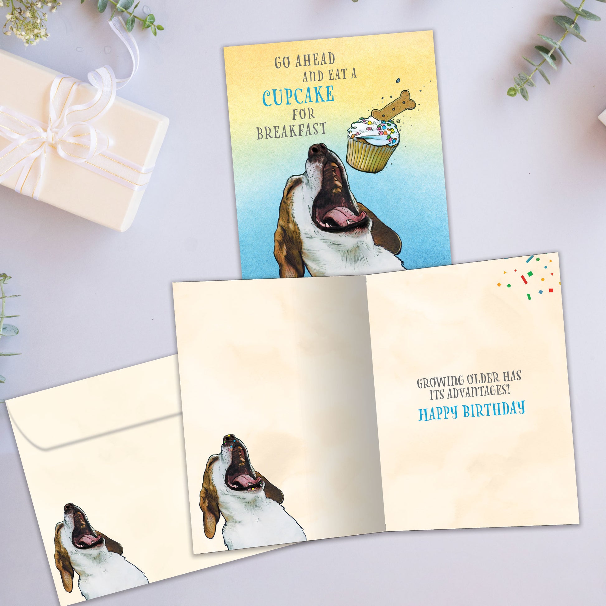 Front and inside view of a Birthday greeting card showcasing a playful image of a dog eating a cupcake and a fun message, with a matching envelope