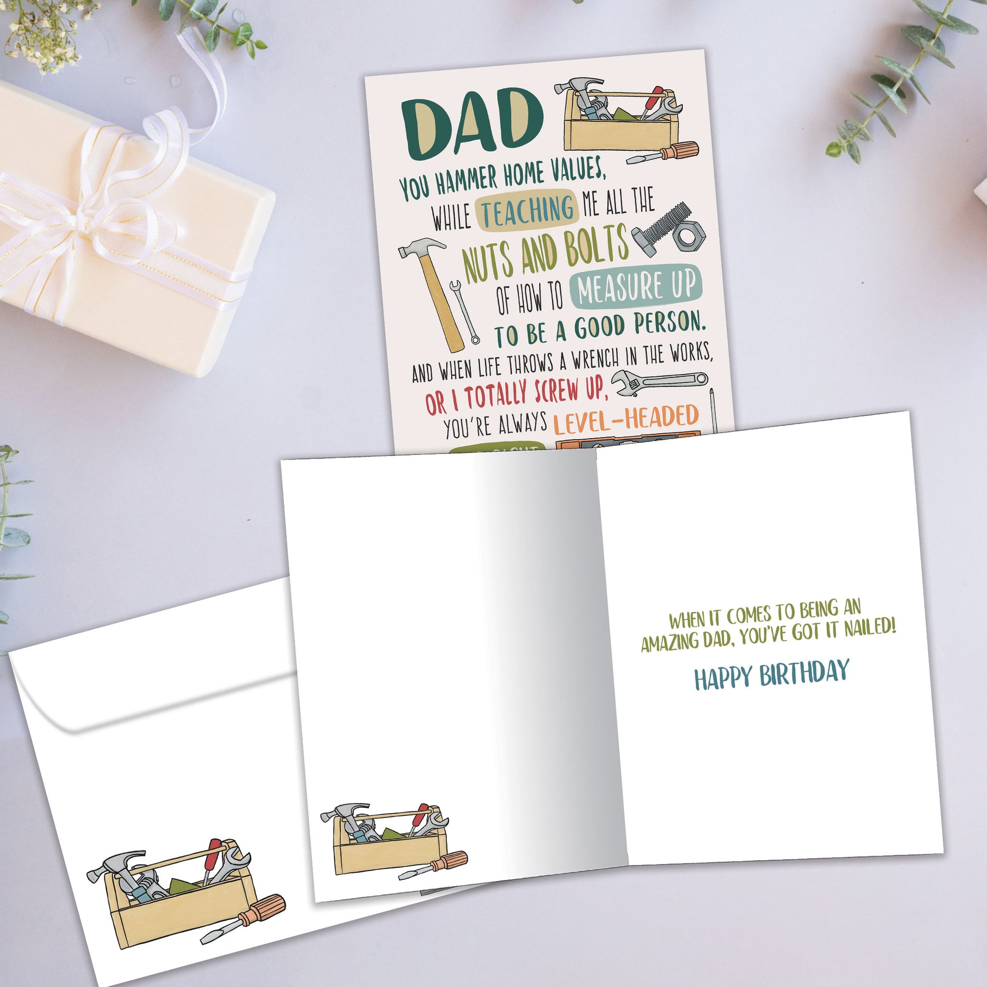 Front and inside view of a Birthday greeting card showcasing a message to Dad and images of various tools, with a matching envelope