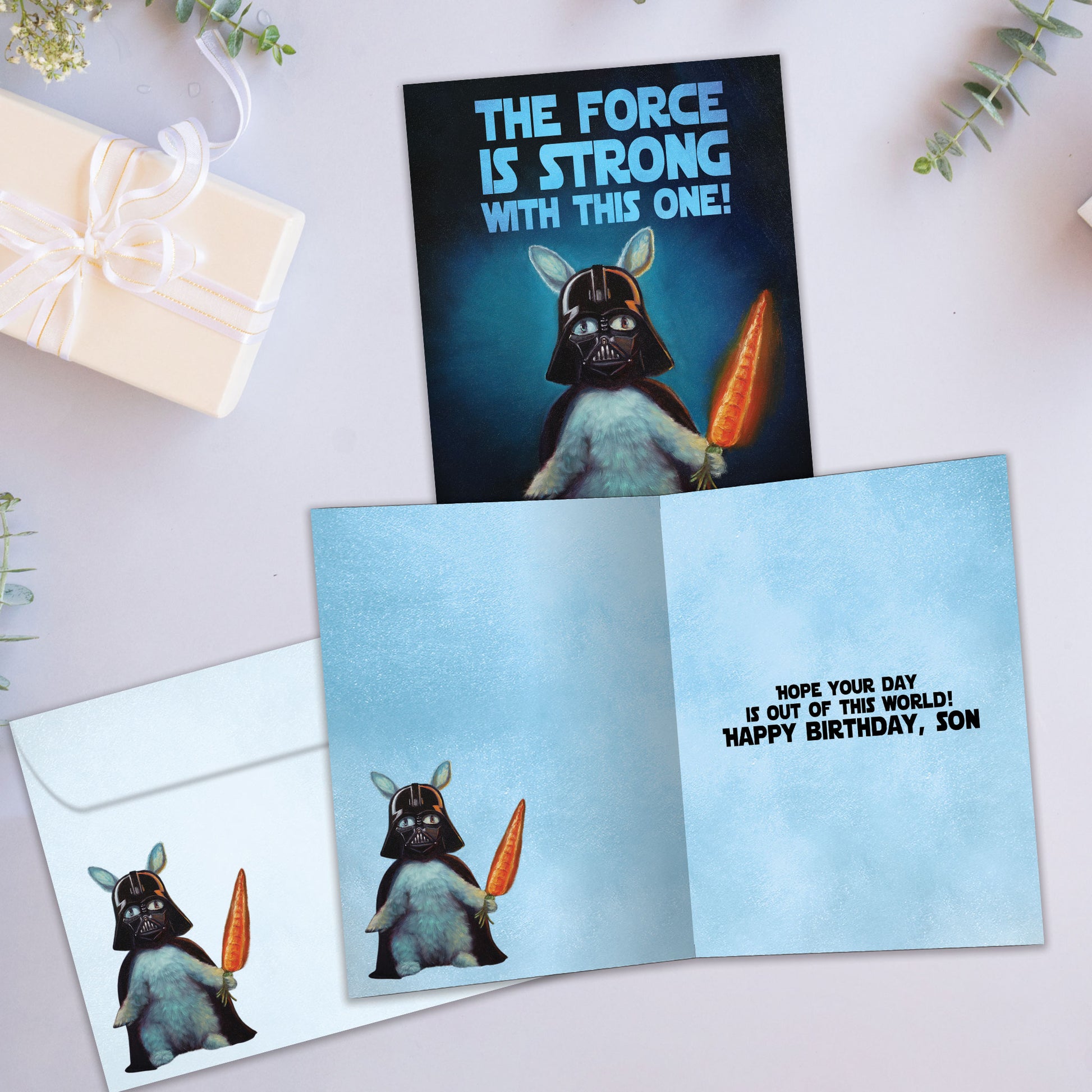Front and inside view of a Birthday greeting card showcasing a bunny dressed up as Darth Vader and a message, with a matching envelope
