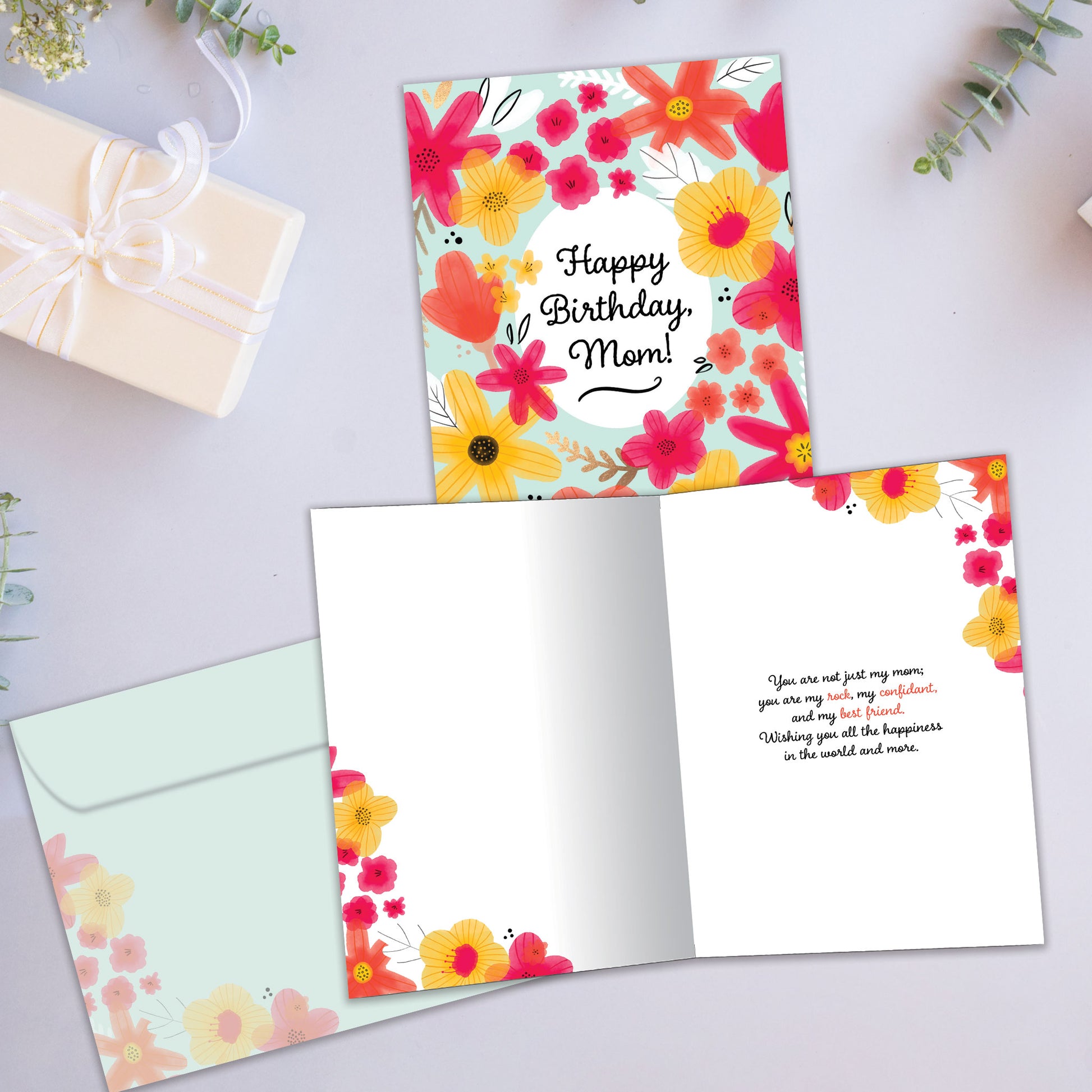 Front and inside view of a Birthday greeting card showcasing a floral design surrounding the message "Happy Birthday, Mom!", with a matching envelope