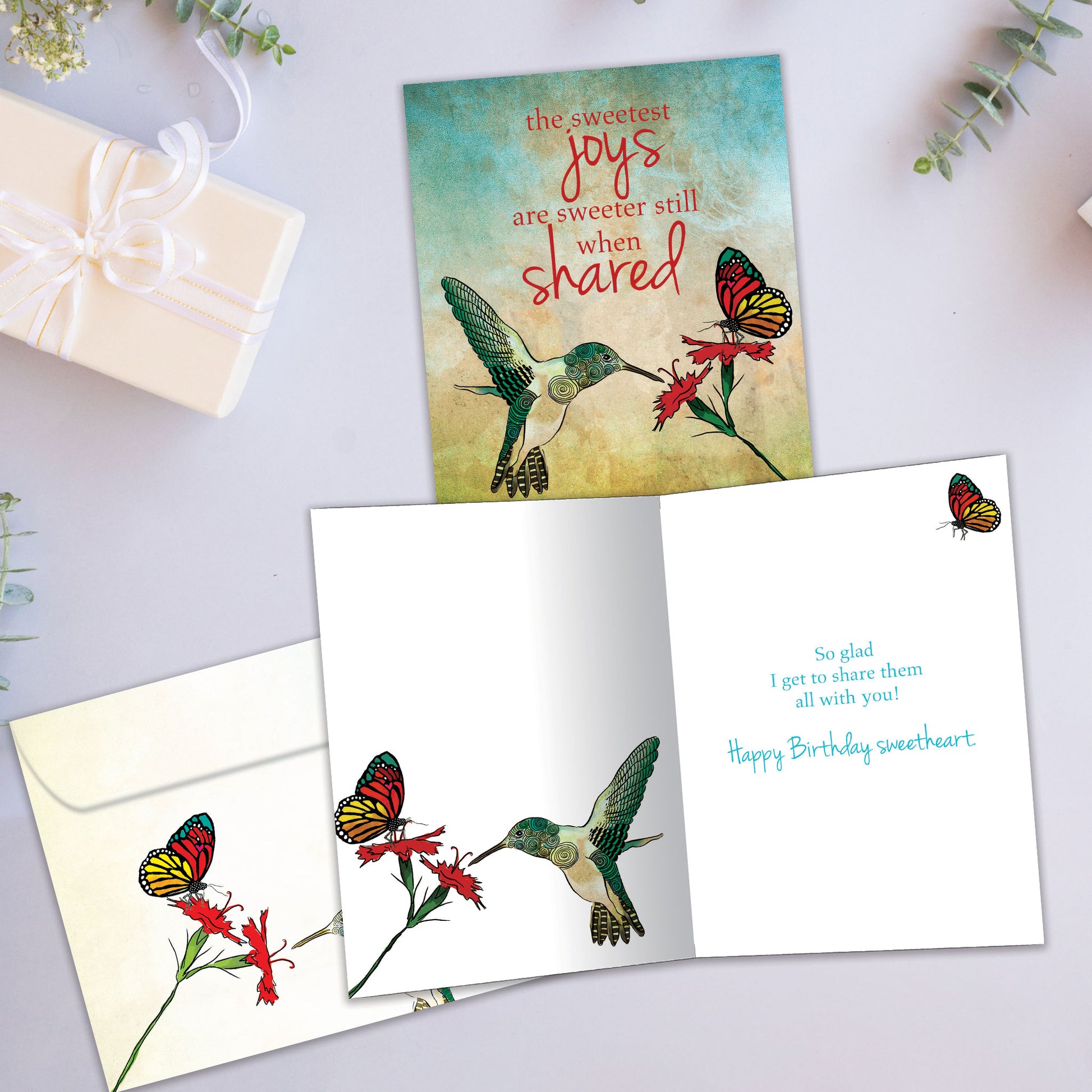 Front and inside view of a Birthday greeting card showcasing a flower, humming bird and butterfly and sweet message, with a matching envelope.